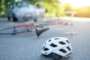 A bicycle laying on the ground after impacting with a car.
